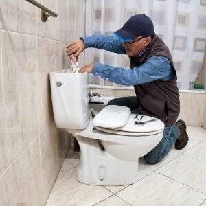 Plumber repairing a toilet cistern