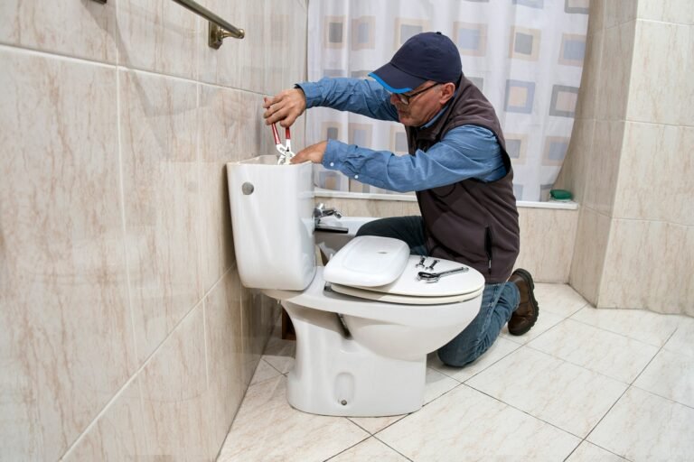 Plumber repairing a toilet cistern